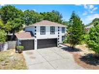 Two-story home boasts a three-car garage, crisp white paint, and contrasted black trim at 809 Deer Glen Ct, Fruitland Park, FL 34731