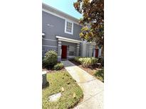 Inviting townhome with well-manicured landscaping and a vibrant red front door, offering a charming curb appeal at 10914 Savannah Wood Dr # 139, Orlando, FL 32832