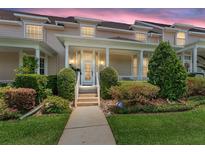 Inviting two-story townhome featuring a charming front porch and beautifully landscaped front yard with manicured bushes at 152 Riggings Way, Clermont, FL 34711