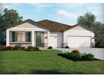 Charming single-story home showcasing a two-car garage, stone accents, manicured lawn and a beautifully landscaped front yard at 2357 Citrus Bloom Dr, Bartow, FL 33830