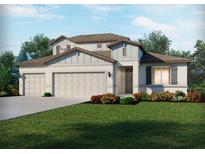 Charming two-story home with three-car garage, manicured lawn, and colorful flowerbeds at 2368 Citrus Bloom Dr, Bartow, FL 33830