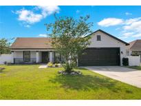 Charming single-story home featuring a well-manicured lawn and a two car garage at 2406 Placid Way, Kissimmee, FL 34758