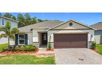 Charming single-story home with a two-car garage, landscaped yard and neutral color palette at 2836 Sanctuary Dr, Clermont, FL 34714