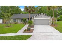 Charming single-story home with stone accents, manicured lawn, and two-car garage on a sunny day at 2901 Autumnwood Trl, Apopka, FL 32703