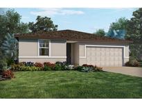 Charming single-story home with a well-manicured lawn and colorful landscaping at 3210 Viceroy Ct, Poinciana, FL 34759