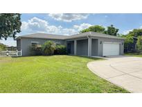 Charming single-story home featuring a well-manicured lawn and attached two-car garage at 344 Buenaventura Blvd, Kissimmee, FL 34743