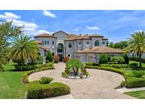 Stately luxury home boasts professional landscaping, circular driveway, and a tile roof at 4071 Isabella Cir, Windermere, FL 34786