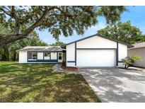 Charming single-story home with a manicured lawn and a large shade tree in a desirable neighborhood at 4901 Lindsay Ct, Orlando, FL 32821