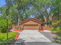 Charming home featuring a two-car garage, inviting walkway, and lush landscaping at 5 W Village Dr, Oviedo, FL 32765