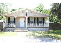 Charming single-story home featuring a covered front porch, a welcoming entrance, and neatly landscaped surroundings at 5054 Mcdonald Rd, Zellwood, FL 32798