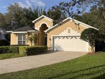 Charming single Gathering home with a well-maintained lawn, mature landscaping, and a two car garage at 563 Pleasant Grove Dr, Winter Springs, FL 32708