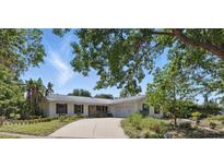 Charming single-story home features a stone accent wall, a wide driveway, and lush, mature landscaping at 6327 Ridgeberry Dr, Orlando, FL 32819