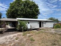 Exterior of home with siding, front door, and carport on lot with grass and trees at 749 Saddlewood Blvd, Lakeland, FL 33809
