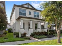 Two-story home with a well-kept lawn and a welcoming front porch with columns and landscaped garden at 9425 Holliston Creek Pl, Winter Garden, FL 34787