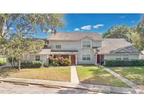 Charming two-story townhome with a well-maintained lawn and sidewalk leading to a welcoming front entrance at 9616 River Walk Ct, Orlando, FL 32825