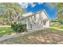 Charming home featuring mature trees, light-colored siding, and well-maintained landscaping at 9616 River Walk Ct, Orlando, FL 32825