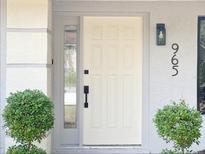 Inviting front door with sidelight, black hardware, and neatly trimmed bushes enhancing curb appeal at 965 Brentwood Dr, Apopka, FL 32712