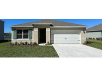 Charming single-story home featuring a pristine two-car garage and neatly landscaped front yard under a clear blue sky at 1000 Ellerston St, Daytona Beach, FL 32124