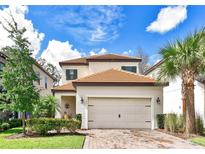 Charming two-story home featuring a tile roof, neutral stucco exterior, and a brick paver driveway at 1147 Wildmeadow Run, Winter Park, FL 32792