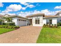 Stunning single-story home with a tile roof, brick driveway, and manicured landscaping at 13791 Abberwick Dr, Orlando, FL 32832