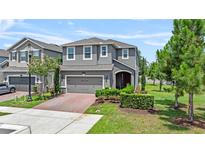 Charming two-story home features a well-manicured lawn and an inviting entrance with a brick driveway at 1425 Paget Cv, Sanford, FL 32771