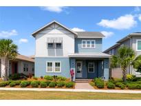 Charming two-story home featuring a landscaped yard, two tone exterior, and inviting front porch at 14525 Englert Aly, Orlando, FL 32827
