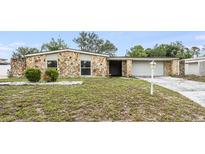 Charming single-story home featuring stone accents, an attached garage, and a well-manicured front yard at 1470 Winston Rd, Maitland, FL 32751