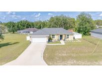 Charming single-story home featuring a well-manicured lawn and attached two car garage at 15303 Sw 52Nd Cir, Ocala, FL 34473