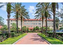Stately building with red tiled roof, palm trees and inviting walkway at 1602 Alabama Dr # Ph404, Winter Park, FL 32789