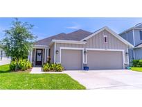 Charming single-Gathering home featuring a two-car garage, well-manicured lawn, and inviting front entryway at 17840 Passionflower Cir, Clermont, FL 34714