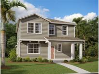 Inviting two-story home with a covered porch, lush landscaping, and a well-manicured lawn at 2371 Zuni Road, St Cloud, FL 34771