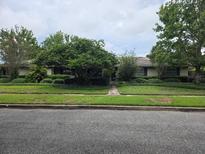 Charming single-story home with lush landscaping and mature trees lining the front yard at 2817 Fitzooth Dr, Winter Park, FL 32792