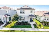 Charming two-story home with a well-maintained lawn and landscaping, featuring a welcoming front porch at 4063 Roaming Brook Dr, Apopka, FL 32712
