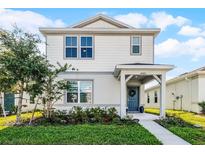 Charming two-story home featuring a welcoming front porch, beautiful landscaping, and a freshly painted exterior at 4063 Roaming Brook Dr, Apopka, FL 32712