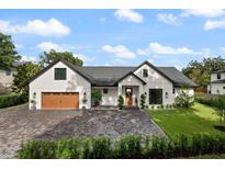 Stunning single-Gathering home with a manicured lawn, brick driveway and modern design under a beautiful blue sky at 5237 Haverill Dr, Orlando, FL 32809