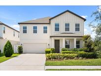 Charming two-story home with a well-manicured lawn and attached two-car garage at 5700 Iron Brand Rd, St Cloud, FL 34771