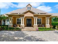 Stunning home exterior featuring a grand entrance with stone accents and a manicured lawn at 5950 Blakeford Dr, Windermere, FL 34786