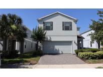 Charming two-story home with a two-car garage and brick paver driveway, set amongst a landscaped yard at 8926 Zurich Ln, Kissimmee, FL 34747