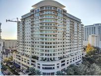Stunning exterior of a modern high-rise condominium building with numerous balconies and lush landscaping at 100 S Eola Dr # 611, Orlando, FL 32801