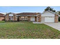 Charming brick home featuring a well-manicured lawn and a welcoming double-door entrance at 2018 N Normandy Blvd, Deltona, FL 32725