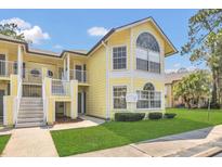 Charming yellow condo with well-manicured lawn and covered entryway at 2040 Royal Bay Blvd # 31, Kissimmee, FL 34746