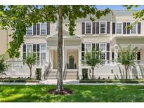 Charming two-story townhouse with black shutters, a well-manicured lawn, and attractive landscaping at 476 Water St, Celebration, FL 34747