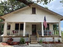 Charming, vintage home with a inviting front porch, American flag, and white painted wood siding at 485 Palm St, Winter Garden, FL 34787