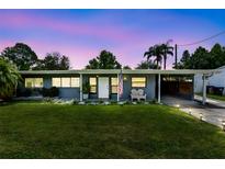 Charming single-story home featuring a well-maintained lawn and stylish curb appeal enhanced by an attached carport at 5384 Barton Dr, Orlando, FL 32807