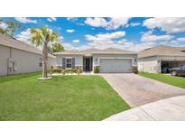 Charming single-story home with a well-manicured lawn, brick driveway, and blue shutters under a beautiful sky at 6013 Mount Zion Cir, Deland, FL 32724