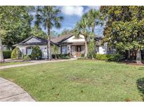 Charming single-story home features a lush lawn, palm trees, and a brick walkway leading to the inviting front entrance at 612 Golden Dawn, Apopka, FL 32712