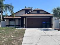 Charming single-Gathering home with a well-maintained lawn, a two-car garage, and beautiful landscaping at 6554 Meritmoor Cir, Orlando, FL 32818