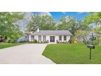 Charming single-story home with a manicured lawn, a concrete driveway, and fresh landscaping at 708 S Laurel Ave, Sanford, FL 32771