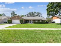 Charming brick ranch home with a lush green lawn and well-maintained landscaping at 7618 Majestic Pine Ct, Orlando, FL 32819