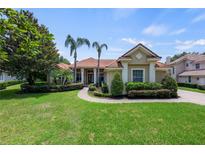 Charming home with a red tile roof, manicured lawn, and lush landscaping at 8475 Eagles Loop Cir, Windermere, FL 34786